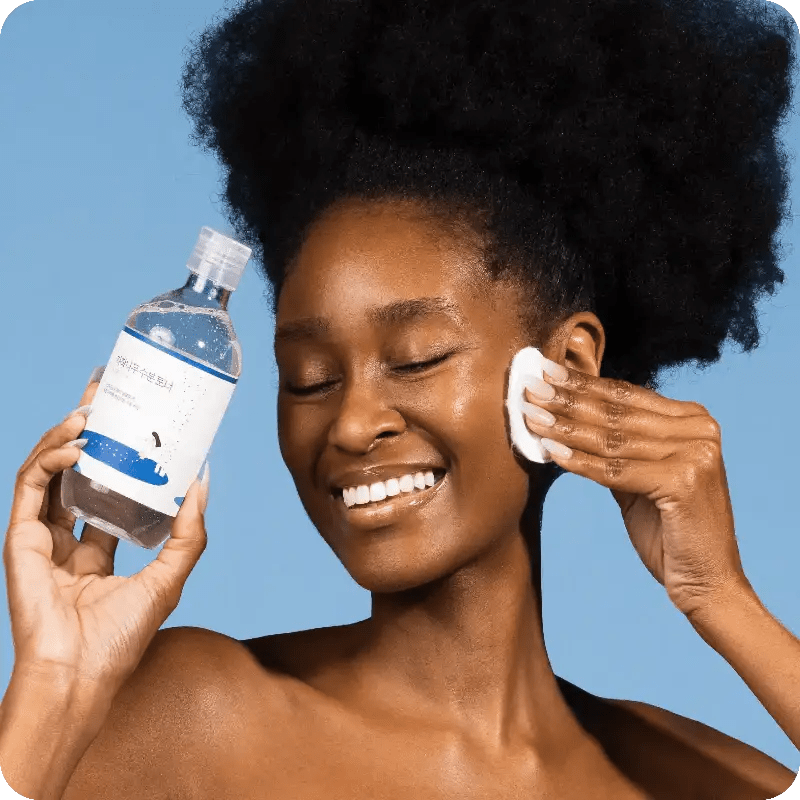 Model applying ROUND LAB Birch Juice Moisturizing Toner with a cotton pad